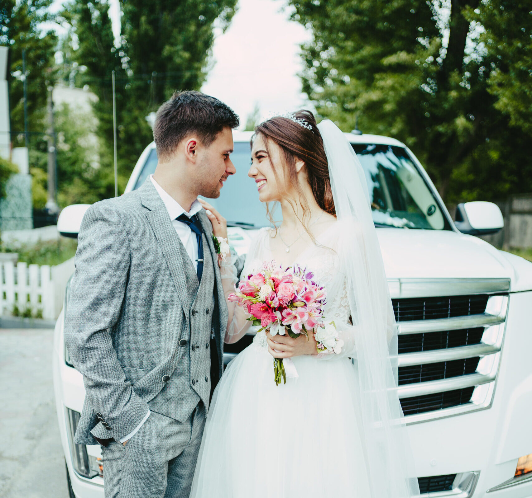 The bride and groom in front of the limousine