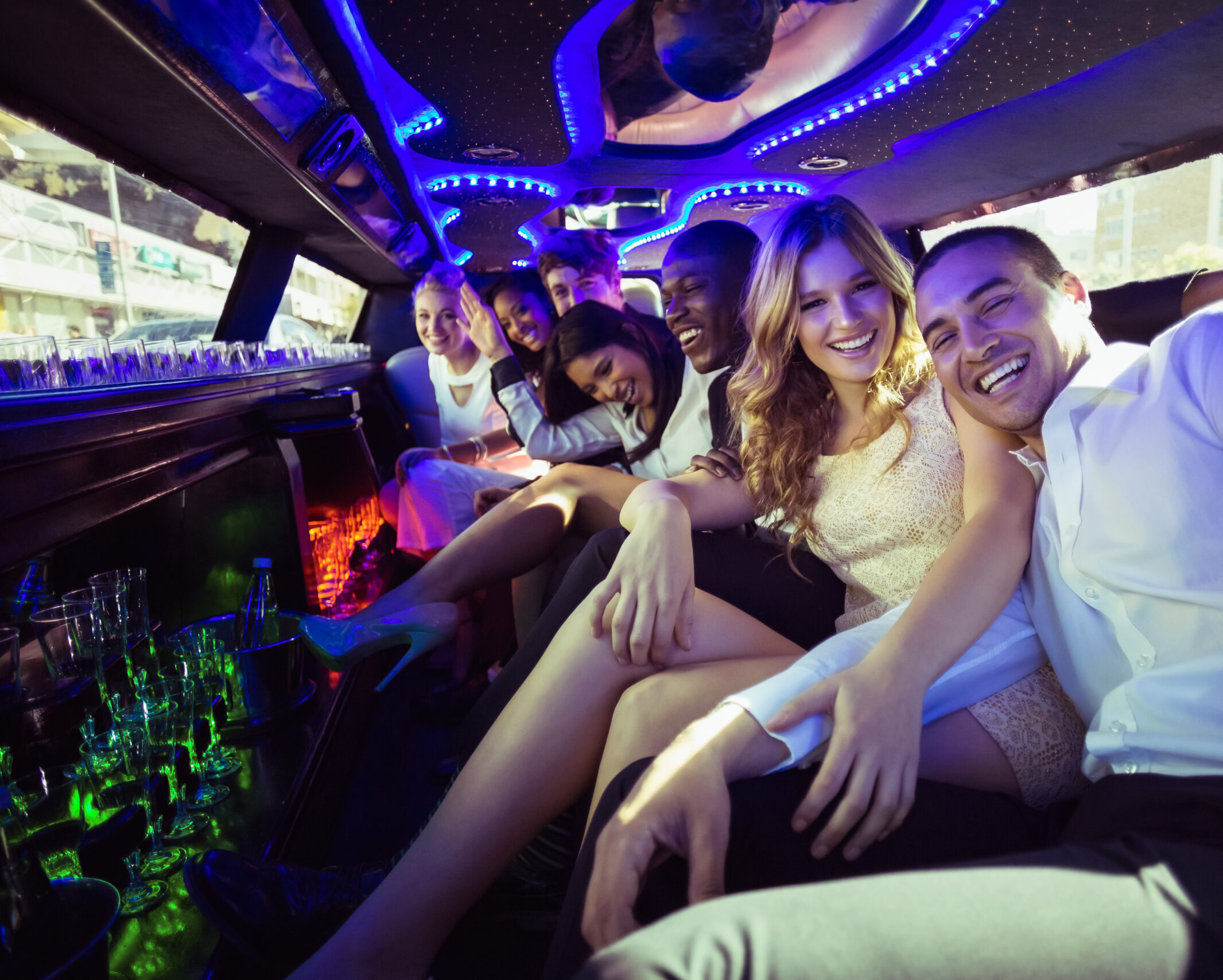 Happy friends chatting in limousine on a night out